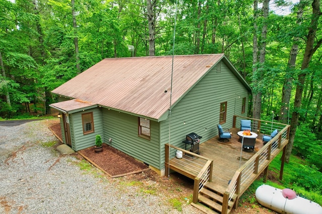 back of house featuring a deck and an outdoor fire pit