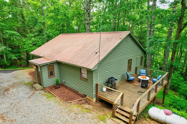 back of house with a wooden deck and an outdoor fire pit