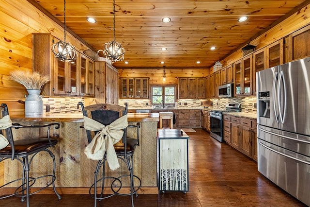 kitchen featuring a peninsula, brown cabinets, wooden ceiling, and appliances with stainless steel finishes