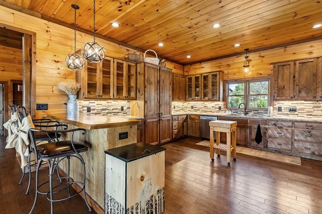 kitchen with tasteful backsplash, a kitchen breakfast bar, glass insert cabinets, brown cabinetry, and stainless steel dishwasher