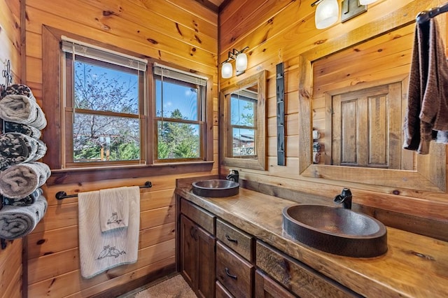 full bathroom featuring double vanity, wooden walls, and a sink
