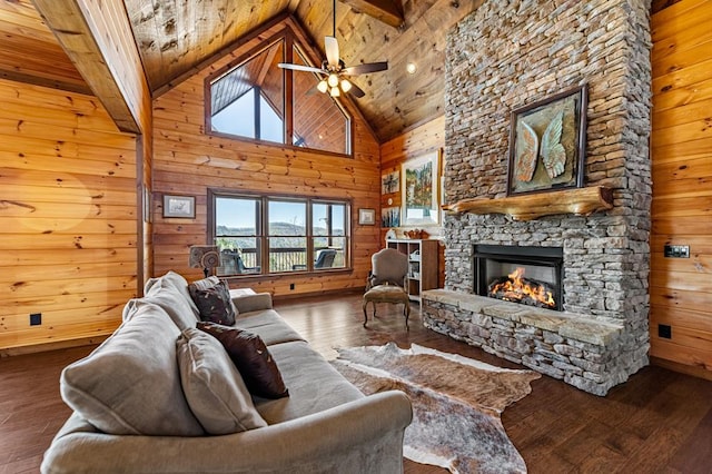 living area featuring wooden ceiling, a stone fireplace, hardwood / wood-style flooring, wood walls, and high vaulted ceiling
