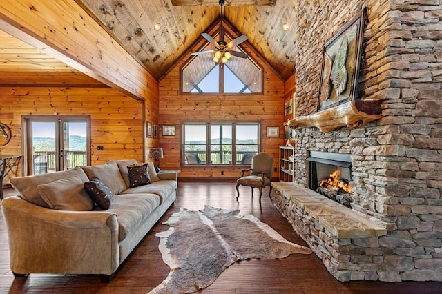 living room featuring ceiling fan, a fireplace, wood ceiling, wood walls, and wood-type flooring