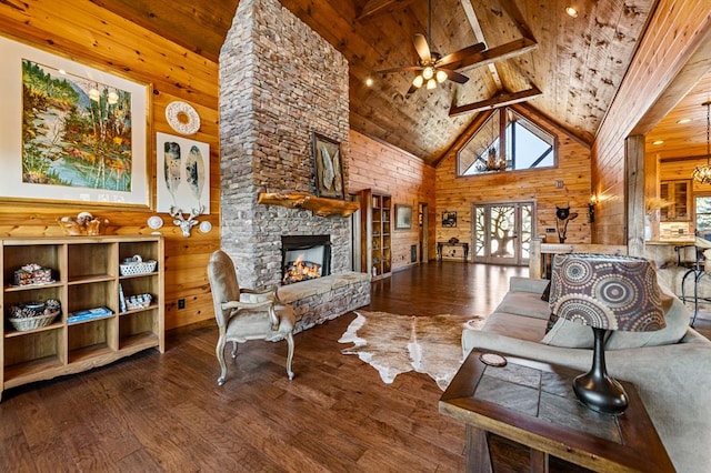living area featuring wood walls, high vaulted ceiling, a stone fireplace, and wood ceiling