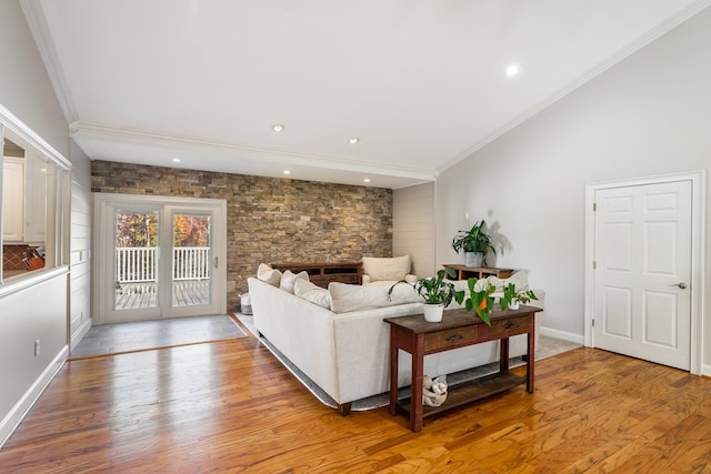 living area with baseboards, ornamental molding, and light wood finished floors
