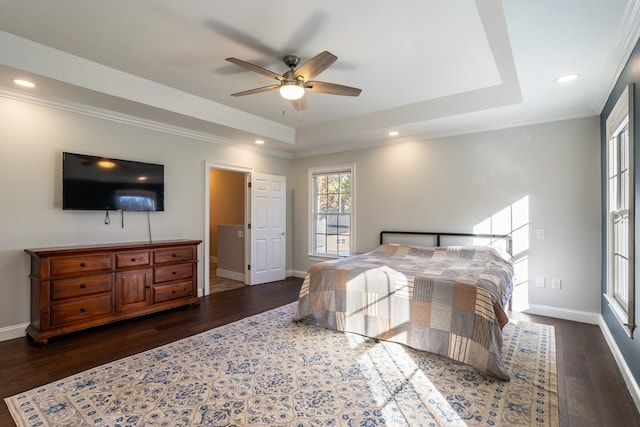 bedroom featuring recessed lighting, dark wood-type flooring, a tray ceiling, baseboards, and ornamental molding