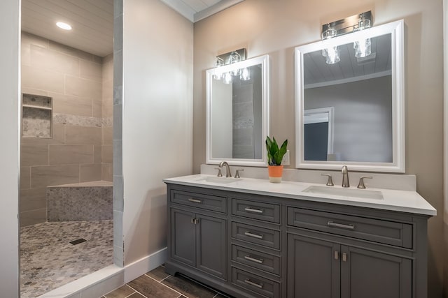 full bathroom with a tile shower, double vanity, a sink, and wood finished floors
