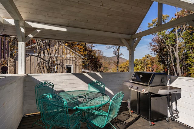 deck with outdoor dining space and area for grilling