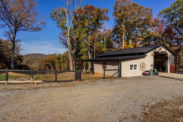 exterior space with fence, an outdoor structure, a pole building, and a mountain view
