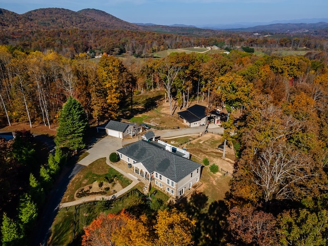 birds eye view of property with a mountain view and a forest view