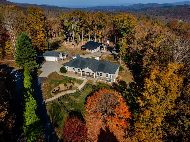 drone / aerial view with a mountain view and a view of trees
