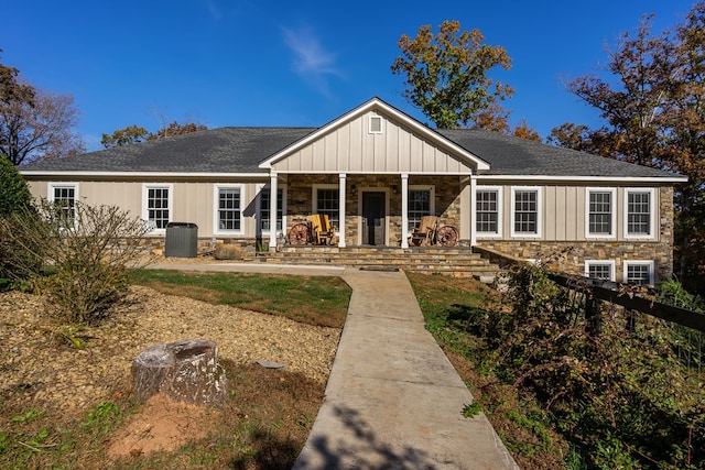 view of front of house featuring covered porch, board and batten siding, roof with shingles, and stone siding