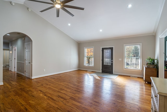 entrance foyer featuring arched walkways, a ceiling fan, wood finished floors, and a healthy amount of sunlight
