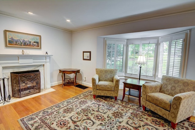 living area with crown molding, baseboards, plenty of natural light, and wood finished floors