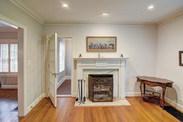 living room with baseboards, ornamental molding, and wood finished floors