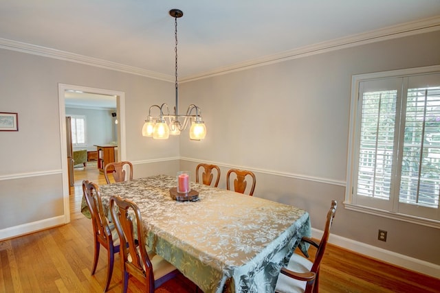 dining space featuring baseboards, ornamental molding, and light wood-type flooring