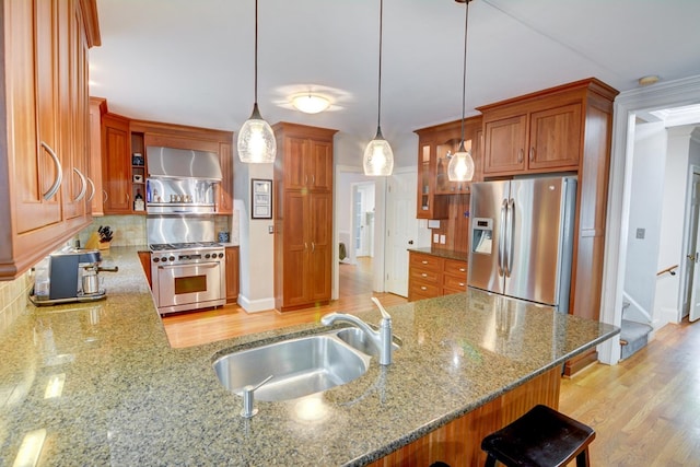 kitchen featuring a sink, decorative backsplash, appliances with stainless steel finishes, and light stone countertops