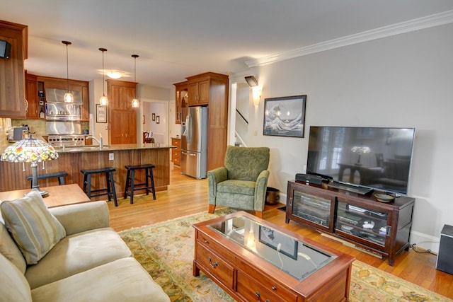 living room featuring stairs, baseboards, ornamental molding, and light wood-type flooring