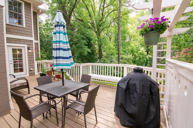 wooden terrace featuring grilling area and outdoor dining space