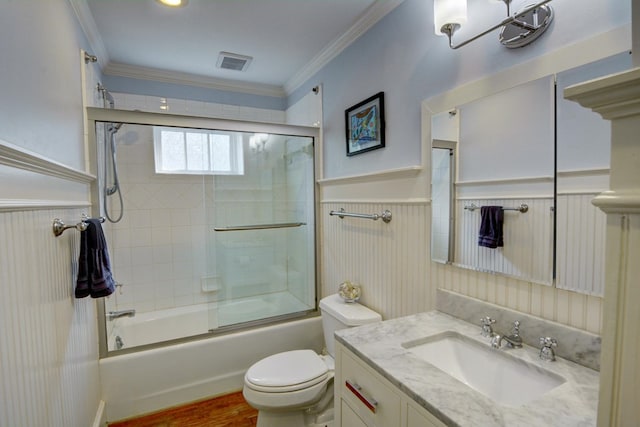 full bathroom featuring visible vents, a wainscoted wall, vanity, toilet, and shower / bath combination with glass door