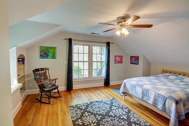 bedroom with visible vents, baseboards, a ceiling fan, light wood-style flooring, and vaulted ceiling