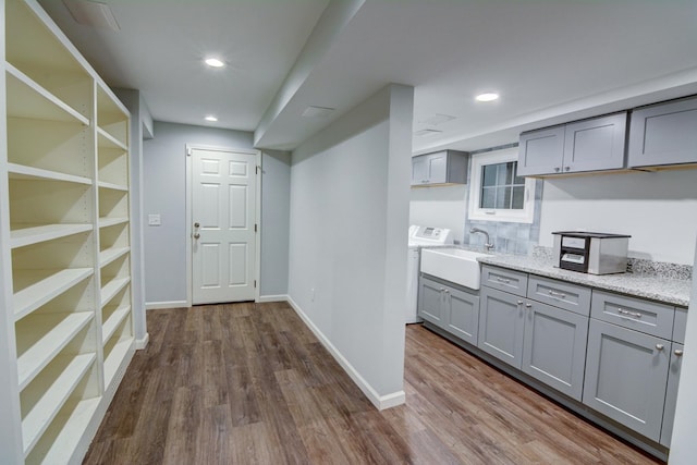 corridor featuring a sink, baseboards, recessed lighting, and dark wood finished floors