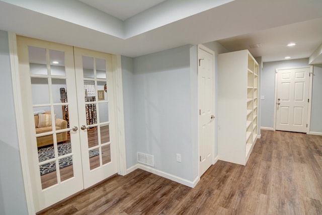 interior space with visible vents, wood finished floors, baseboards, recessed lighting, and french doors