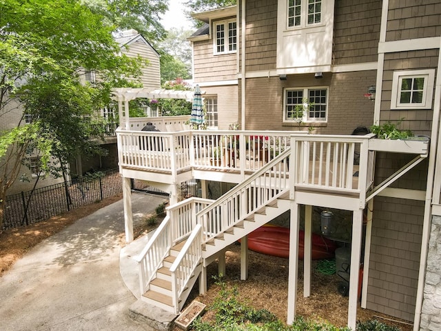 deck with fence, a pergola, and stairs