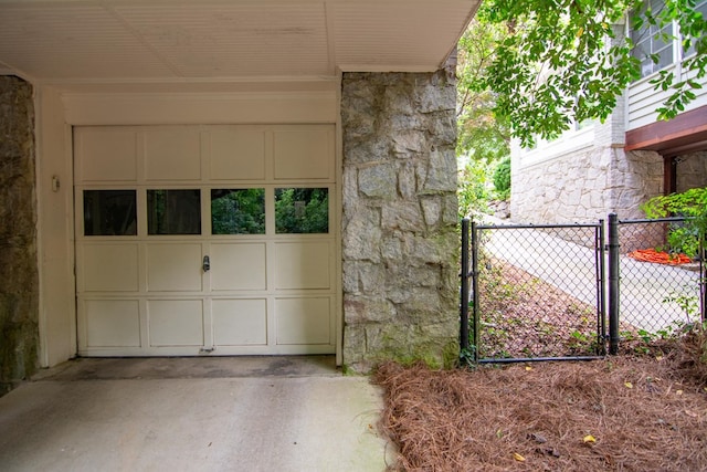 garage featuring fence and driveway
