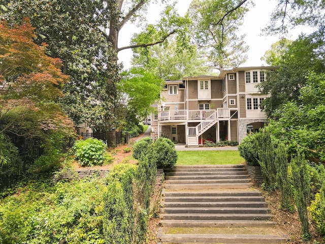 exterior space with a deck, fence, and stairs