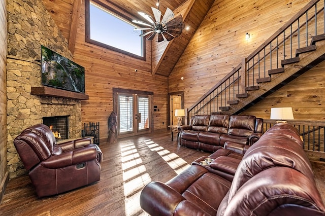 living room with wood ceiling, hardwood / wood-style floors, a stone fireplace, and high vaulted ceiling