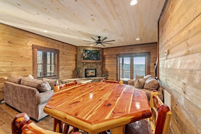 dining room featuring plenty of natural light, hardwood / wood-style floors, wood ceiling, and a fireplace