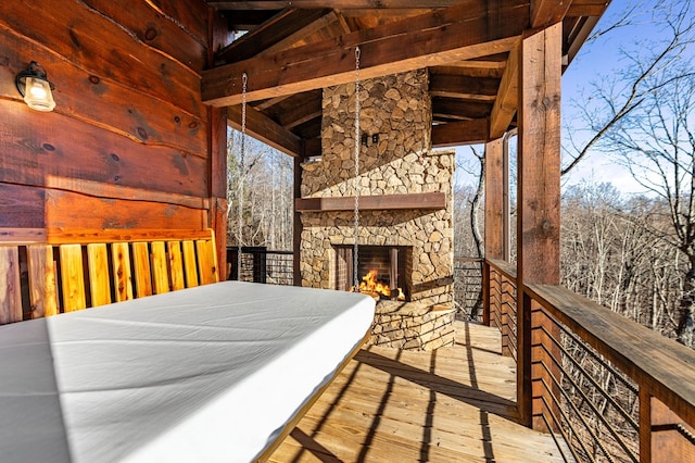 wooden deck featuring an outdoor stone fireplace