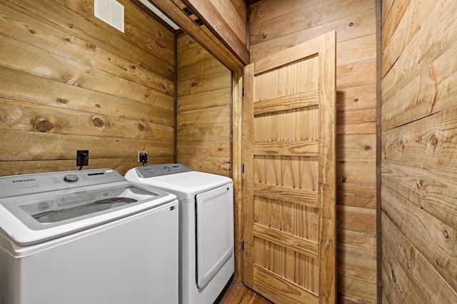 washroom featuring independent washer and dryer and wooden walls