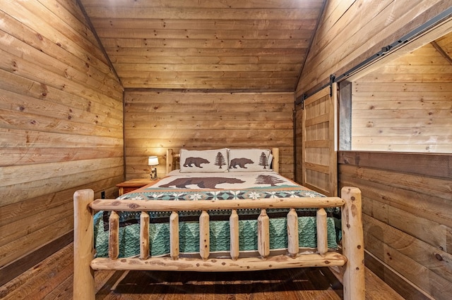 unfurnished bedroom with wood ceiling, a barn door, and vaulted ceiling