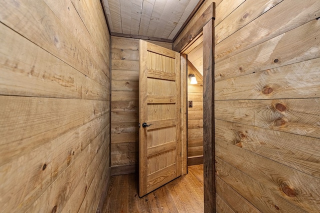 hallway featuring wooden ceiling, wood-type flooring, and wood walls