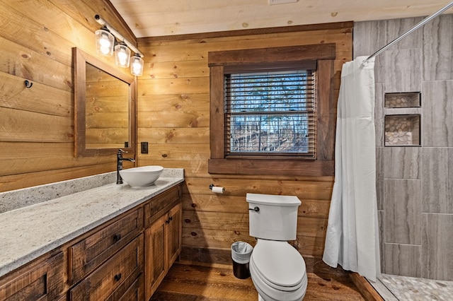 bathroom featuring toilet, wood walls, hardwood / wood-style floors, walk in shower, and vanity