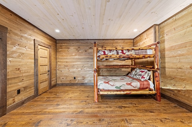 unfurnished bedroom featuring wood ceiling, wood walls, and hardwood / wood-style flooring