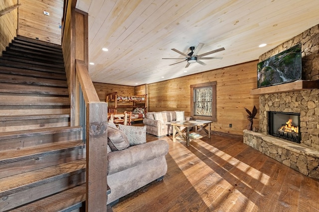 living room featuring ceiling fan, wood-type flooring, a fireplace, and wood ceiling