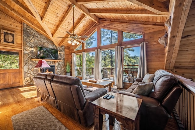 living room featuring vaulted ceiling with beams, a fireplace, hardwood / wood-style floors, ceiling fan, and wooden ceiling