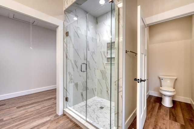 bathroom featuring hardwood / wood-style floors, a shower with shower door, and toilet