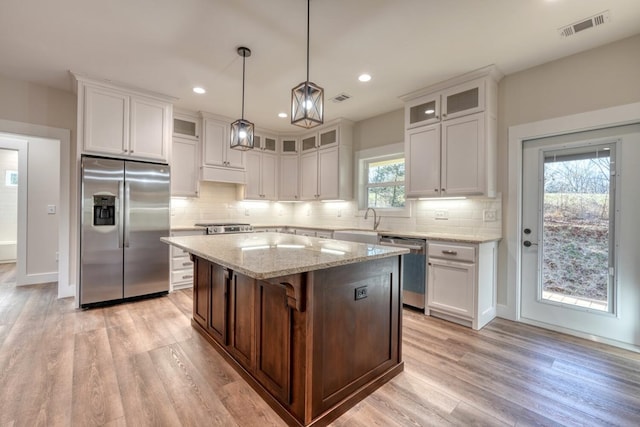 kitchen with stainless steel appliances, white cabinetry, and a kitchen island