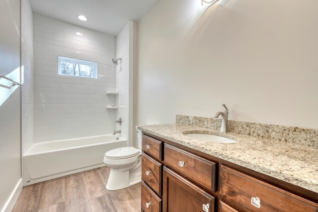 full bathroom with toilet, vanity, hardwood / wood-style flooring, and washtub / shower combination