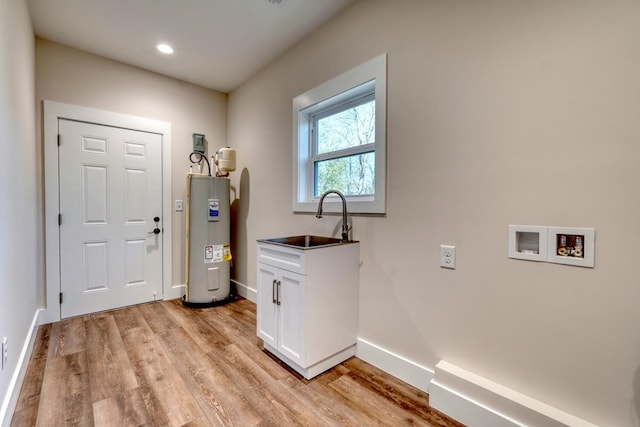 laundry room featuring sink, light hardwood / wood-style flooring, hookup for a washing machine, and electric water heater