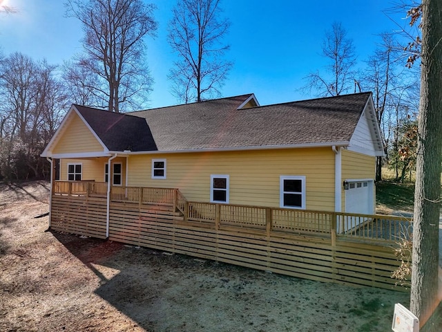 back of house with covered porch and a garage