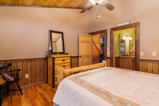 bedroom featuring ceiling fan, light wood-type flooring, wood ceiling, and sink