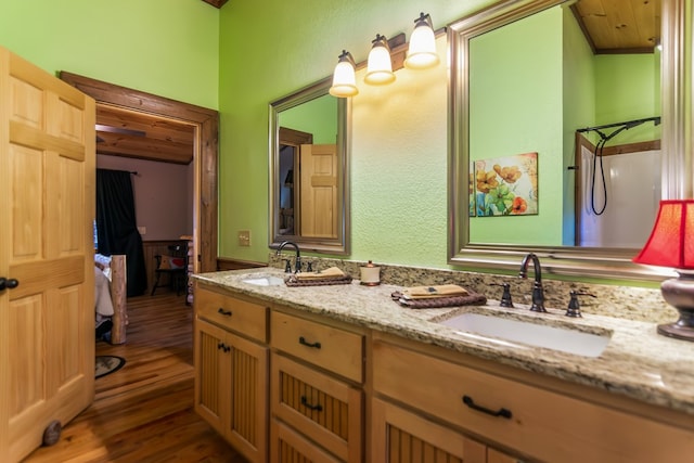 bathroom with walk in shower, vanity, and hardwood / wood-style flooring