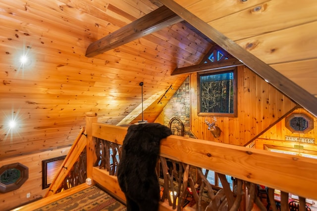 interior space with wooden ceiling, vaulted ceiling with beams, and wooden walls