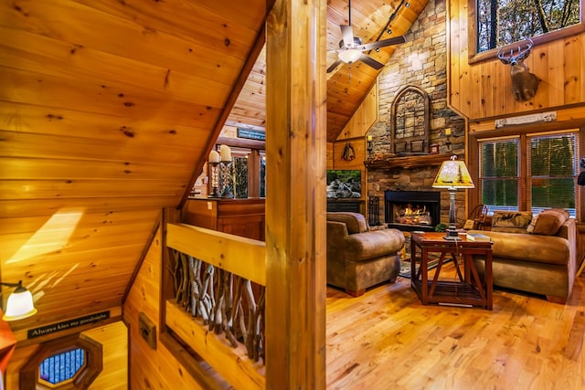 interior space with a fireplace, beamed ceiling, light wood-type flooring, high vaulted ceiling, and wooden ceiling