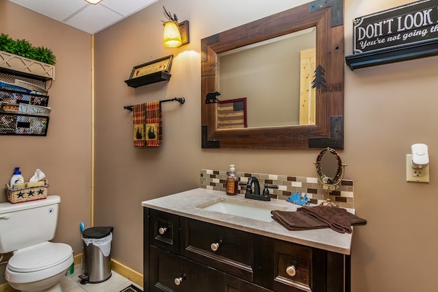 bathroom featuring toilet, vanity, and backsplash